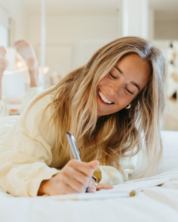 Woman journaling gut health oral hygiene.
